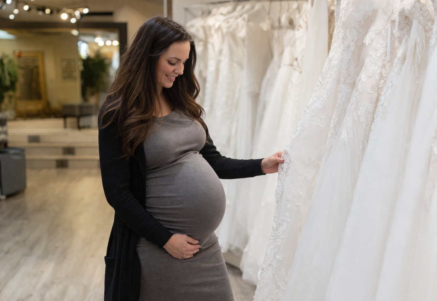 Frau mit Babybauch in einer Boutique für Brautkleider